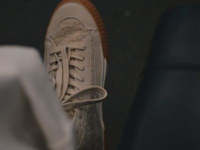 Close-up of athletic shoes on a dark floor.