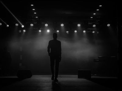 Silhouette of a person stretching against a dark background.